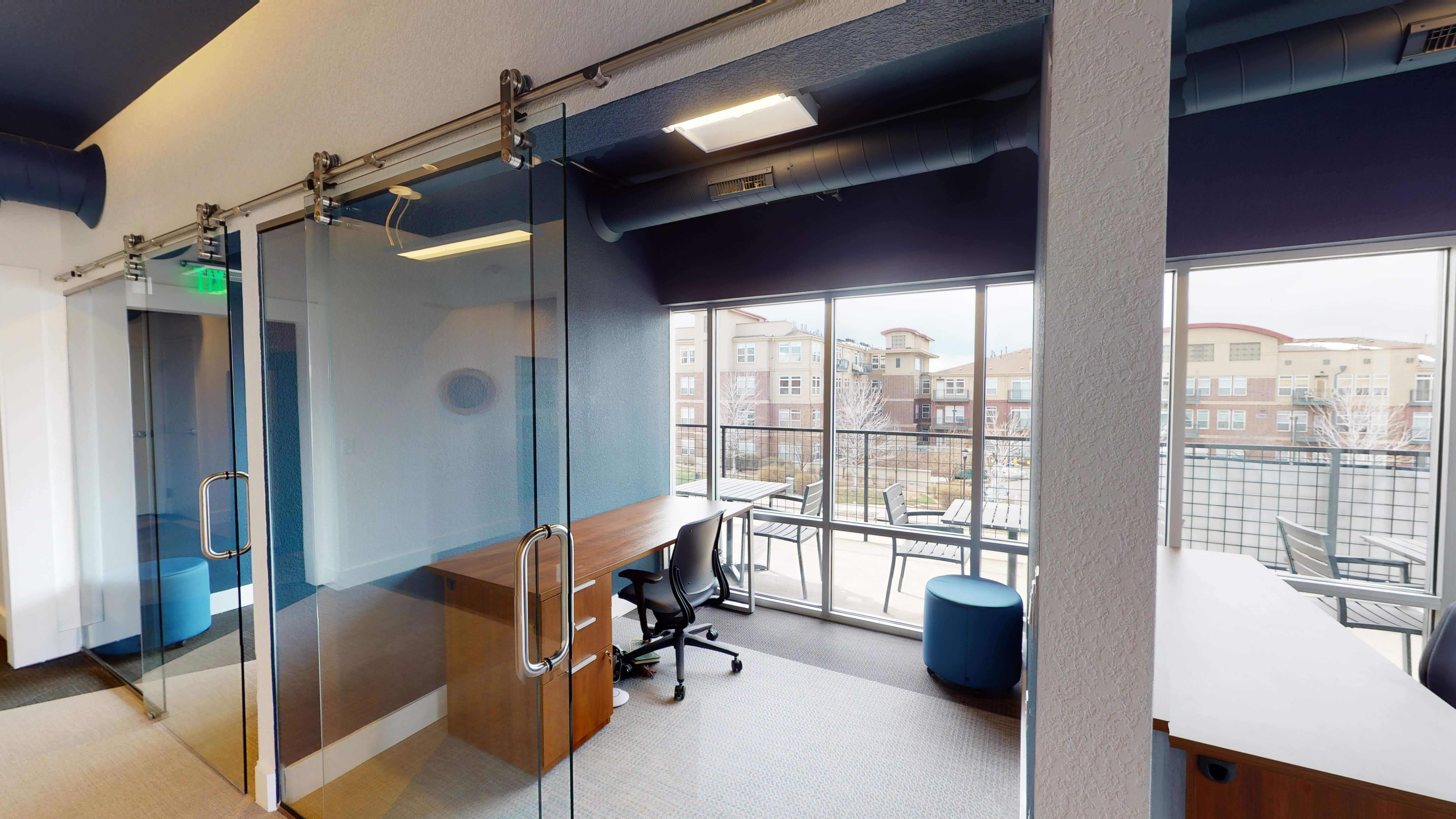Private glass-door phone booths and focus workspaces at The Guild